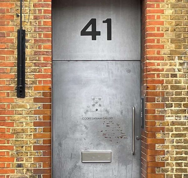 Cooke Latham Gallery entrance with brushed steel door numbered 41, framed by red brick walls