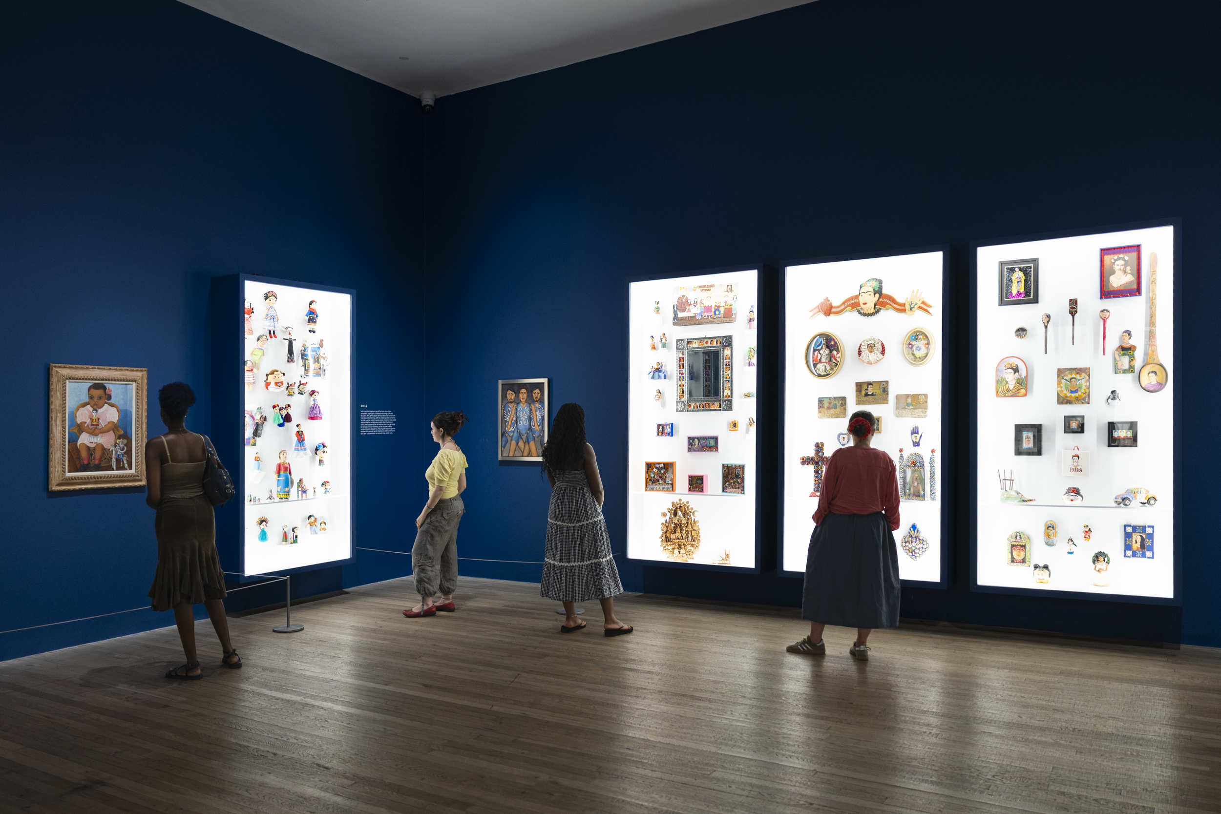 Visitors view Frida Kahlo memorabilia in illuminated display cases at Tate's 'Frida: The Making of an Icon' exhibition